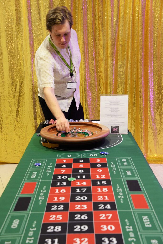 Henkilö pyörittämässä rulettia ja rulettipöytä